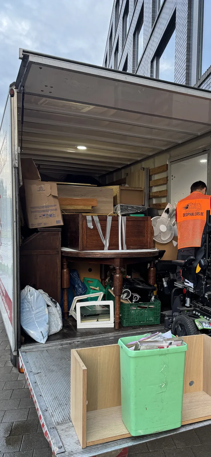 Een geladen bus van De Ophalers met meubels en dozen